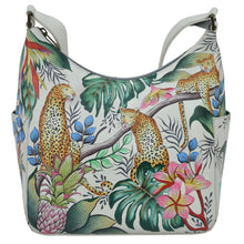 Load image into Gallery viewer, Anuschka style 382, handpainted Classic Hobo With Side Pockets. Jungle Queen painting in Ivory color. Fits Tablet and E-Reader.
