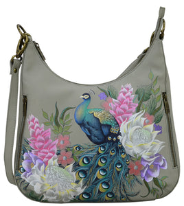 Anuschka style 662, handpainted Convertible Slim Hobo With Crossbody Strap. Regal Peacock Painted in Grey Color. Featuring inside zippered wall pocket, one open wall pocket, two multipurpose pockets with gusset and rear full length zippered pocket, slip in cell pocket.