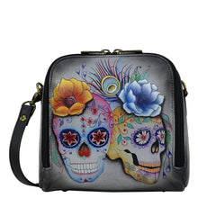 Load image into Gallery viewer, Anuschka style 668, handpainted Zip Around Travel Organizer. Calaveras de Azúcar Painted in Multi Color. Featuring inside four RFID protected card holder, top zippered pocket with gusset, one slip in pocket, one multipurpose pocket with gusset and rear full length slip in pocket with magnetic closure.
